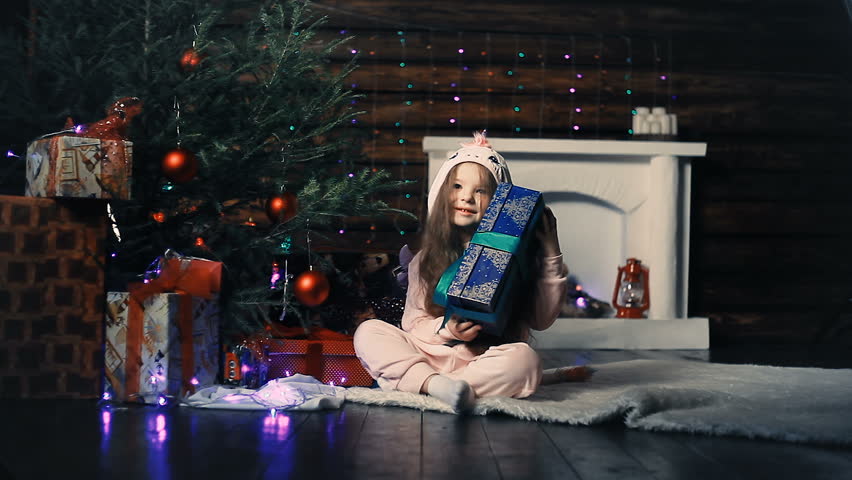 Little girl and Christmas gifts under the tree