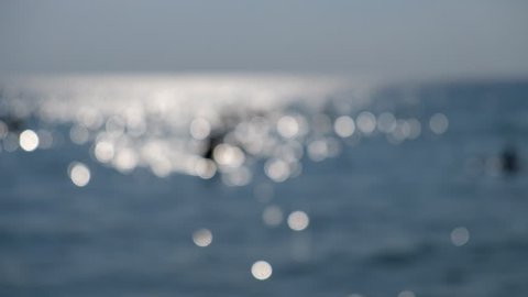 Flowing water on the sea with a bokeh sunlight background.