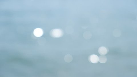 Flowing water on the sea with a bokeh sunlight background.