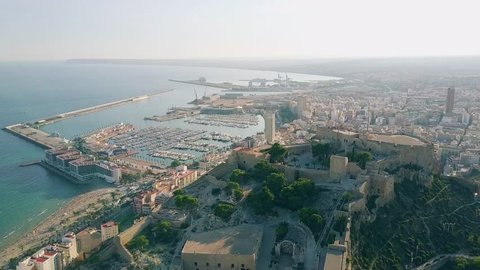 Aerial shot of Alicante cityscape and seaport behind Santa Barbara castle, Spain