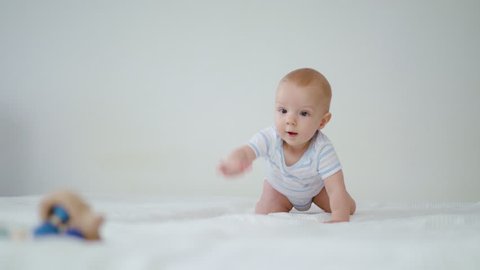 Cute baby crawling on her bed at home. Close-up shot