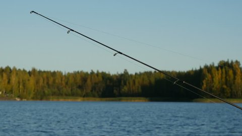 Trolling fishing on lake with reel rod in sunny day, 4k shot