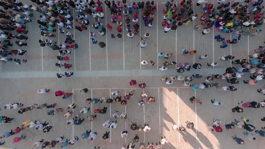 Rotating top view of a diverse crowd in a schoolyard. Royalty-Free Stock Footage #1018790914