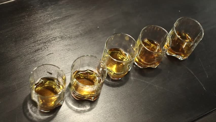 Five friends take a glass of whiskey