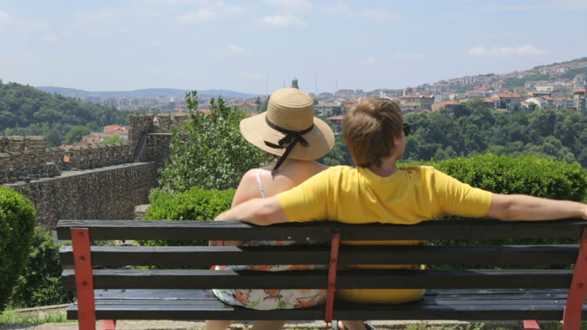 Couple resting on bench in summer day