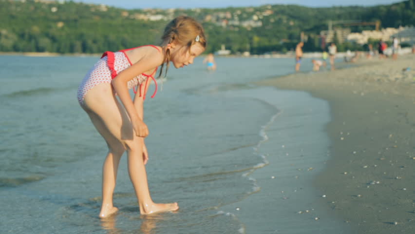 Little girl on coast in summer day