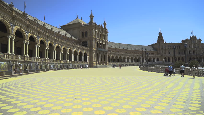 Avenue in Plaza de España in Seville sided by golden buildings.