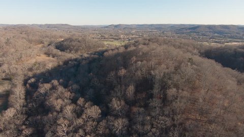 Aerial drone view of rustic southern country during autumn in rural Tennessee from a wide angle. Somber fall season with fields of bare trees before winter.