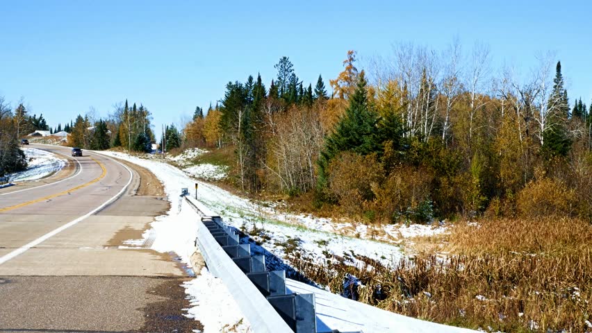 Cars approach bridge over Mississippi River, seen flowing north, about one mile from the source, Lake Itasca. Clip taken from second highway bridge over the river in northern Minnesota.