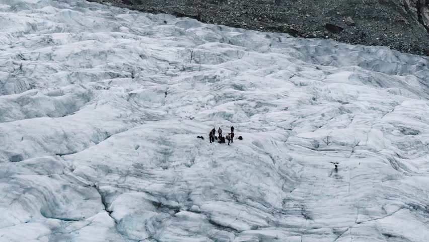 Jostedalsbreen/Nigardsbreen glacier, Norway. Shows two different groups of ice climbers/glacier hikers standing on the center of the glacier, while the video is panning out. 