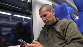 traveler man unknown middle-aged smartphone in the subway writes sms to social media messenger. slow motion video. man metro in railway train. man traveler in train concept travel lifestyle