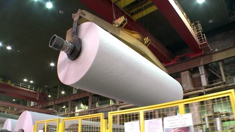 Paper production. Rolls of white offset paper are transferred by huge cranes for further cutting. Filmed in Russia, Komi Republic, 35Mbps, 25P / 1920x1080