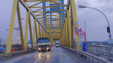 LUBECK, GERMANY - DECEMBER 14, 2017: Bridge with Metal Construction. Yellow Arch Bridge with trucks
