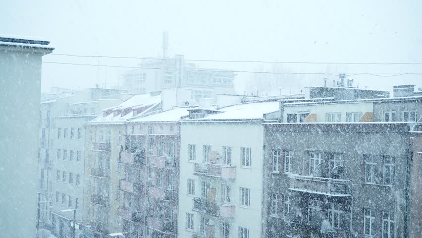 Winter season and seasonal specific. Heavy snowfall snow storm in the city. Urban scene, snowy houses