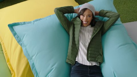 top view successful african american business woman jumping on colorful pillows smiling happy relaxing female resting enjoying success in trendy office workplace
