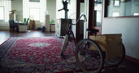 Vintage tricycle on afghan rug in hipster office during the daytime. Medium to closeup shot on 4K RED on a gimbal. วิดีโอสต็อก
