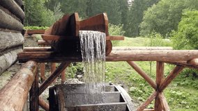 Wooden water turn of miller wheel. Historic medieval village architecture. Static day stabilized shot
