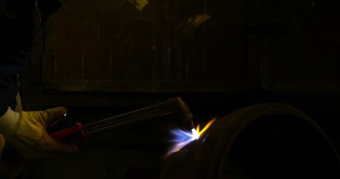 Mid section of metalsmith using welding torch in workshop 4k