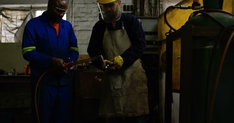 Two metalsmiths lighting welding torch in workshop 4k