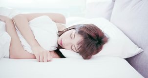 Young beautiful woman sleeping well and stretching arm in the morning