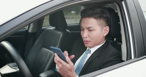 business man use a phone seriously in the car