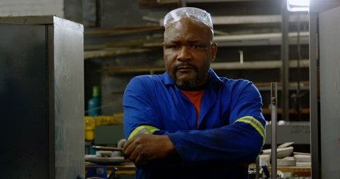Portrait of African-american metalsmith standng with arms crossed in workshop 4k