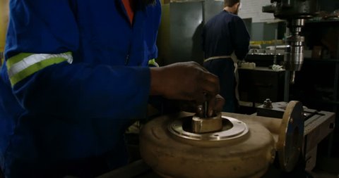 Close up of Attentive African-american metalsmith working in workshop