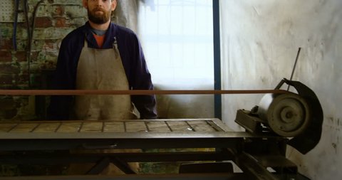 Portrait of caucasian metalsmith standing in workshop 4k
