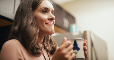 Proud corporate office worker really enjoys drinking her coffee in office kitchen. Medium to closeup shot on 4K RED camera on a gimbal.