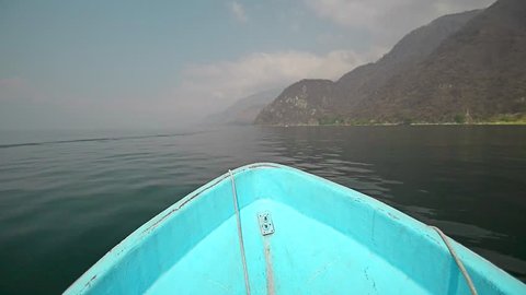 Boat ride in lake Atitlan through misty mountains