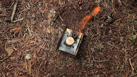 The dry spirits tablet burns on a metal plate in the woods