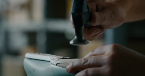 Close up of a shoemaker nailing and fixing the leather of the shoe according to the italian tradition. Concept: handmade, fashion, industrial, factory