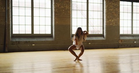 Contemporary dancer dancing in industrial brick and beam loft during daytime. Wide to long shot on 4K RED camera.