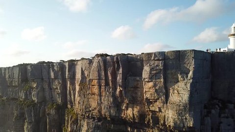 Revealing shot of a cliff face to beautiful sunset on the coast of N.S.W, Australia. The wall is popular with rock climbers.