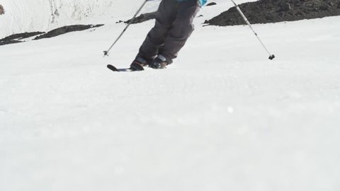 Skier making turn on groomer piste with spray
