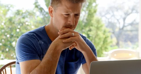 Attentive Caucasian man using laptop at home 4k, 