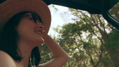 Beautiful woman wearing a hat and sunglasses driving an ATV through a forest in Australia, shaded natural lighting. Close up shot on 4k RED camera.
