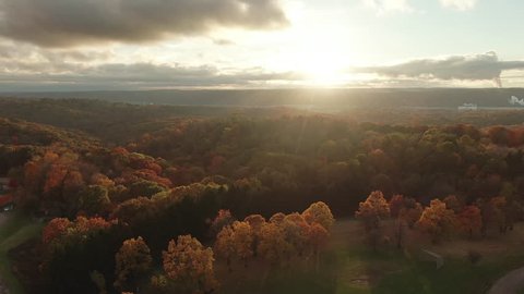 An evening aerial view of the wide colorful Pennsylvania countryside landscape in late Autumn. Flying into the sunset.	 	