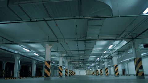 Fluorescent lights flicker and light up and illuminate a large underground parking 