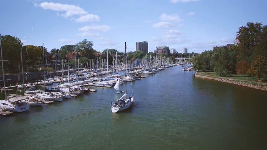 Cinematic chase of a sailing ship entering Oakville marina, Ontario, Canada - drone footage