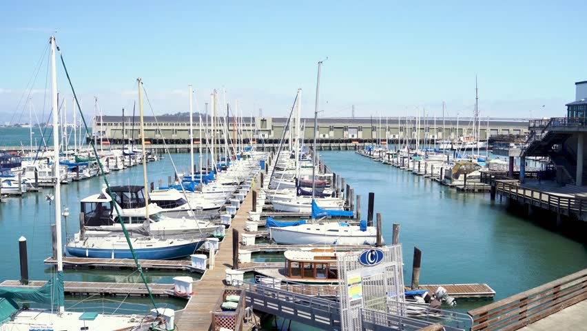 Colorful fishing boats floating on clean ocean in Fisherman Wharf on blue sunny sky. moored boats on quiet peaceful harbor. famous attraction in San Francisco CA.