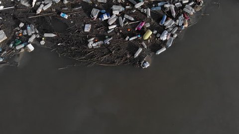 Spain - October 28, 2018: Aerial drone video waterfront scrap-heap garbage pile. Above view plastic bottles rubbish pollution marine debris on lake shore. Global damage environmental dumping concept