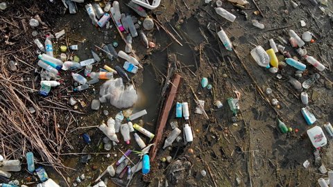 Spain - October 28, 2018: Aerial drone video waterfront scrap-heap pile of garbage. Above plastic bottles rubbish pollution marine debris on lake shore. Global damage environmental dumping concept