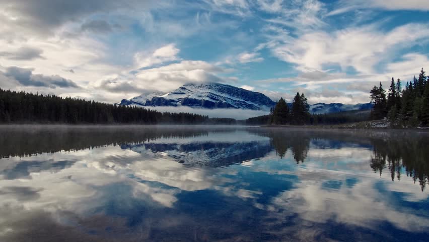 Two Jack Lake timelapse cloudscape and snow mountain reflection in Banff National Park, Canada.