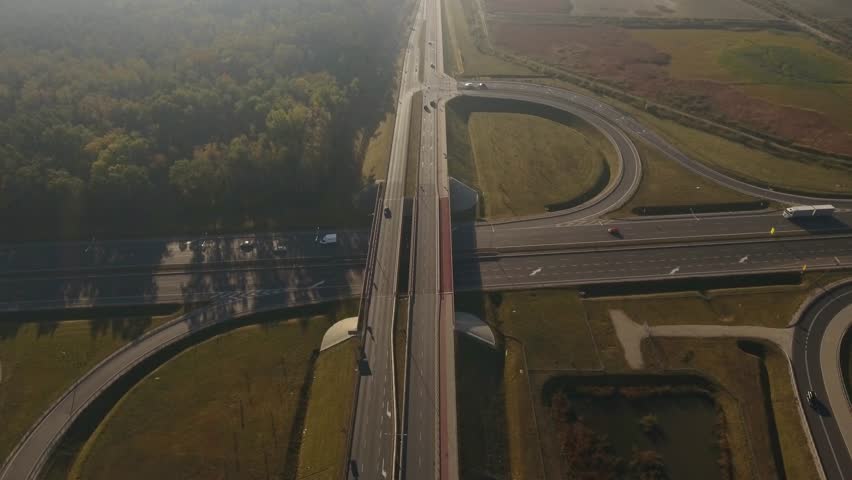 Aerial view of highway road junction in the countryside with trees and cultivated fields. Polish countryside.