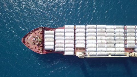 Large general cargo ship loaded with Ammonia containers - Top down aerial footage
