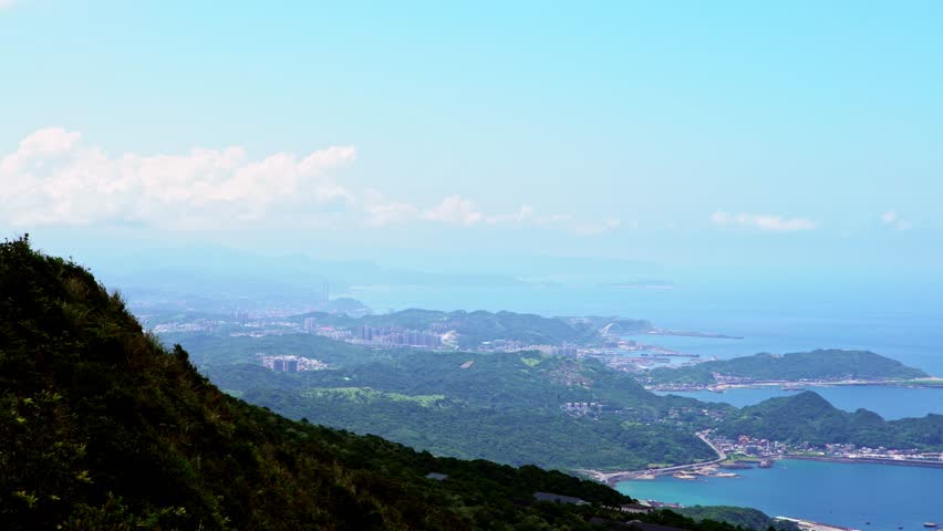 4K, Aerial view of Keelung harbor and mountain in New Taipei city. Beauty landscape of green mountains and port with blue sky. Scenic waterfront at beautiful day of summer in Jishan-Dan