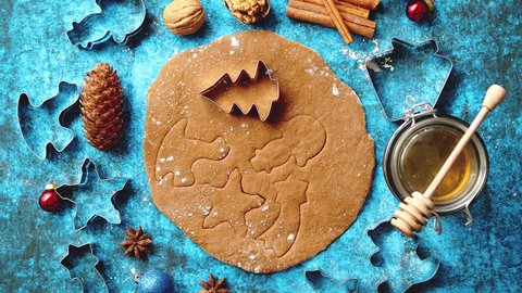 Christmas baking concept. Gingerbread dough with different cutter shapes and spices on sides. Top view on blue rustic background.