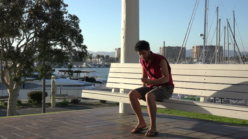 Handsome young tourist taking a selfie at  beautiful boat marina in a tropical resort