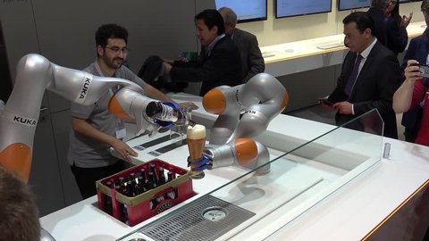 Hannover, Germany - April, 2018: Kuka robot arms pouring beer on Messe fair in Hannover, Germany